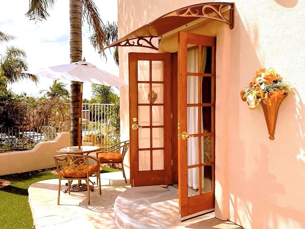 A patio with an umbrella and chairs outside