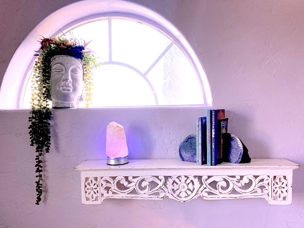 A shelf with books and a lamp on it