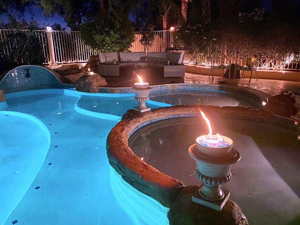 A pool with lit candles in the middle of it.