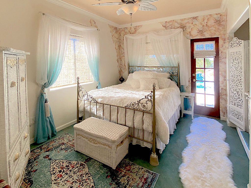 A bedroom with a bed, dresser and window.