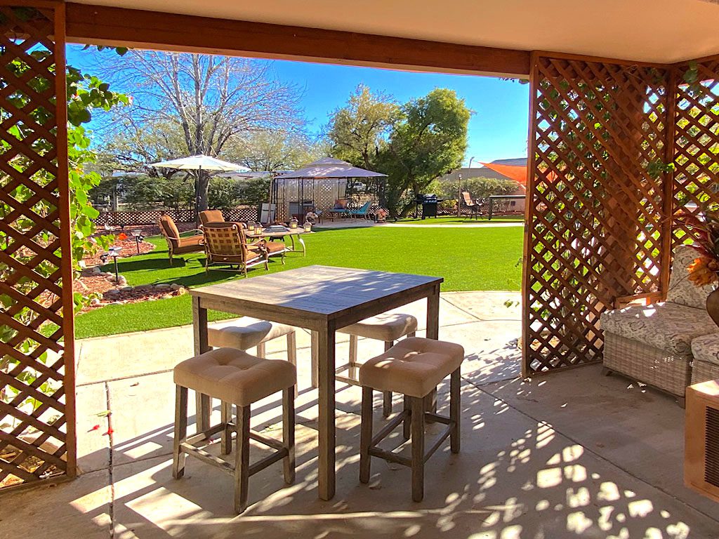 A patio with chairs and tables in the middle of it