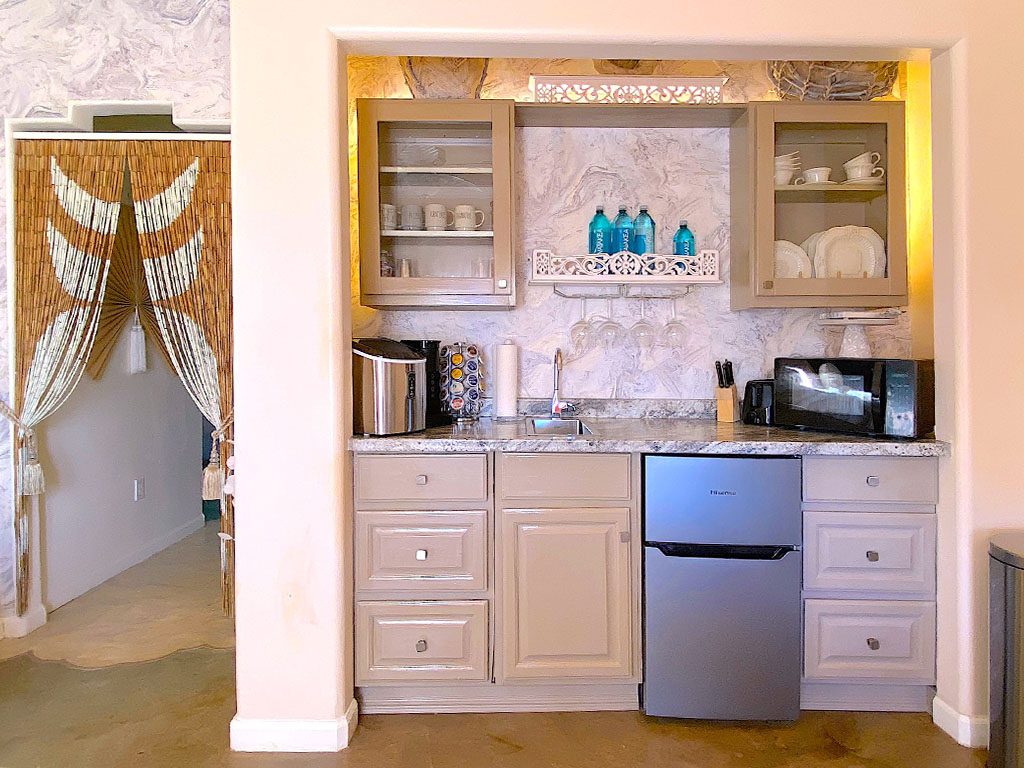 A kitchen with white cabinets and blue accents.