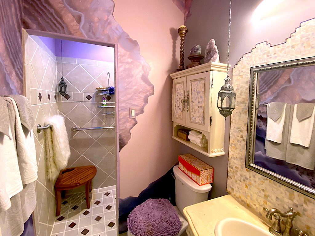 A bathroom with a sink, toilet and mirror.